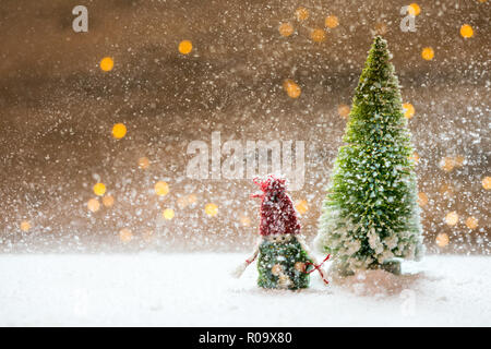 Sybolic avec paysage nature conceptuelle, un seul arbre de Noël vert dans la neige sur fond de lumières blanches Banque D'Images