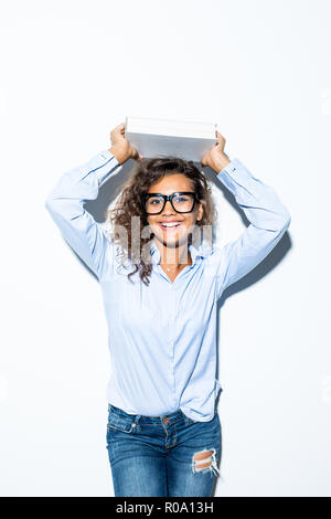 Businesswoman holding tas de livres et de magazines sur la tête, sur fond blanc Banque D'Images