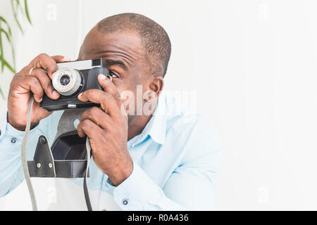 Portrait d'un jeune afro-américain qui prend des photos sur un vieux vintage camera Banque D'Images