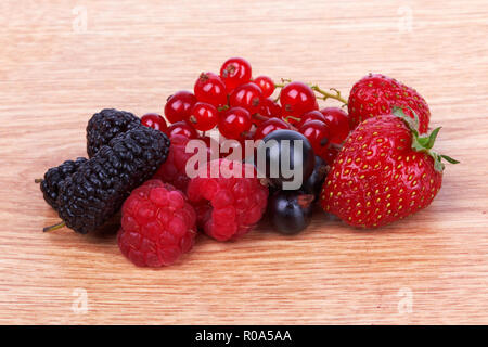 Fraises, framboises, groseilles rouges et mulberry sur un fond de bois Banque D'Images