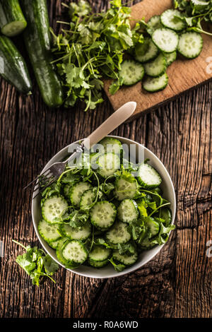 Tranches de concombre sur une assiette avec le persil herb sur bois Chêne rustique. Banque D'Images