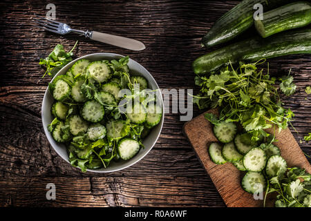 Tranches de concombre sur une assiette avec le persil herb sur bois Chêne rustique. Banque D'Images