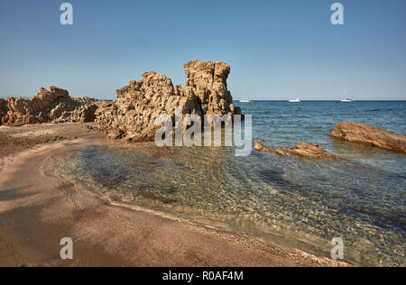 Rocky sud sardaigne plage avec des vagues de mer transparente à venir à terre pour fusionner avec Golden Beach. Banque D'Images