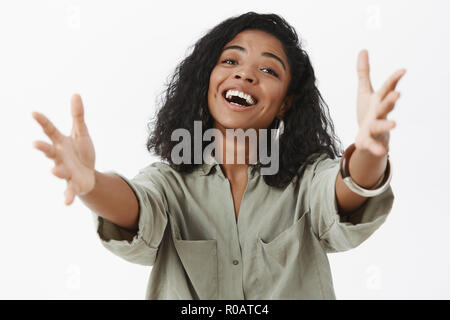 Fille veut des caresses. Portrait de friendly féminin charmant african american woman en le tirant vers la caméra chemisier mains tête inclinable et souriant qui veulent câliner et encen mignon bébé dans les bras Banque D'Images