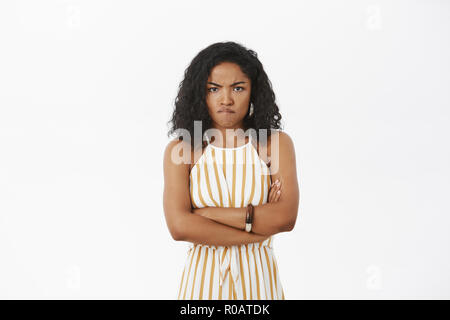 Portrait de fâché et mad cute african american woman with curly hairstyle crossing arms sur la poitrine en infraction de bouder à la colère avec caméra à se sentir insulté et offensé Banque D'Images