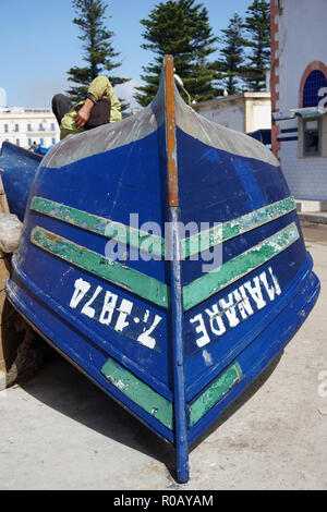 Bateau de pêche en bois bleu et l'homme endormi, Essaouira, Maroc Banque D'Images