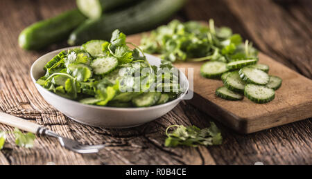 Tranches de concombre sur une assiette avec le persil herb sur bois Chêne rustique. Banque D'Images