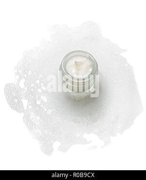 Bocal en verre avec une crème hydratant visage dans une mousse. Banque D'Images