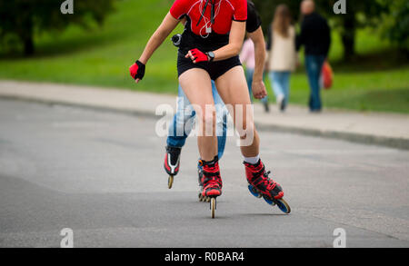 Woman riding sur patins à l'extérieur au skate park Banque D'Images