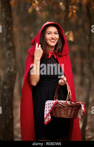 Femme vêtue comme Red Riding Hood dans diverses postures dans la forêt Banque D'Images