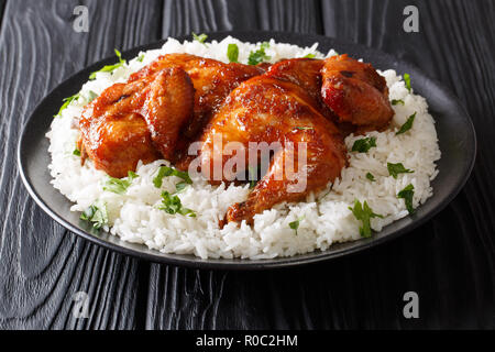 Poulet cuit dans la moitié de l'ail, le soja, le gingembre et sauce au miel servi avec du riz sur une plaque sur un tableau noir. Style asiatique horizontale. Banque D'Images