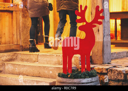 Décor en bois de renne de Noël rouge en ville européenne street. Décorations festives et l'éclairage en hiver vacances en ville. Banque D'Images