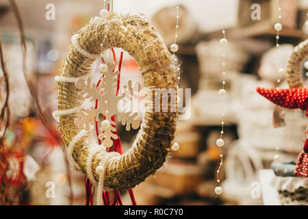 Couronne de Noël rustique et un flocon de neige sur la fenêtre dans la rue ville européenne. Décorations de fête simple et l'éclairage en hiver vacances en ville. Pre Banque D'Images