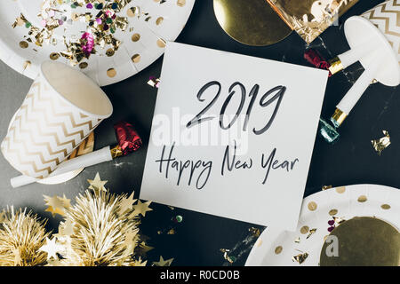 Bonne année 2019 coup de pinceau à la main font en blanc carte de souhaits sur table de marbre avec partie,coupe,ventilateur,parti de guirlandes confettis.Fun célébrer maison de pa Banque D'Images