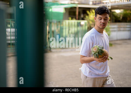 Young Asian man ananas à la maison Banque D'Images