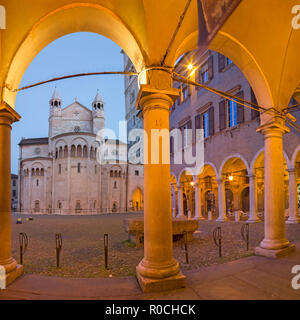 Modena - Les arcades de la Piazza Grande square au crépuscule avec le dôme. Banque D'Images