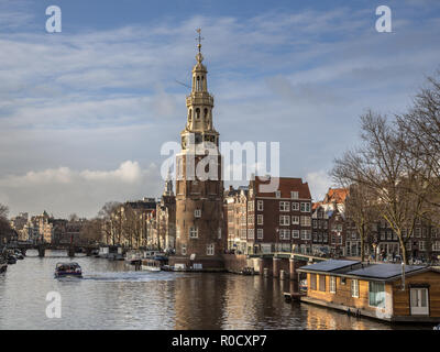 La tour Montelbaanstoren avec péniches et canal historique maisons à Amsterdam Banque D'Images