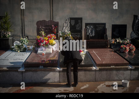 Barcelone, Catalogne, Espagne. 1er novembre 2018. Une femme met des fleurs à un tombeau au cimetière de Poblenou à Barcelone, Catalogne, Espagne, le 1 novembre 2018. La Toussaint, la fête catholique traditionnel dédié à la mémoire des ancêtres, est célébré le jour de novembre et 1 personnes visitent les cimetières de se rappeler les êtres chers disparus et le lieu des fleurs dans sa tombe. Crédit : Jordi Boixareu/ZUMA/Alamy Fil Live News Banque D'Images