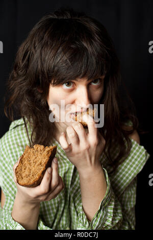 Portrait d'un pauvre mendiant woman eating bread Banque D'Images