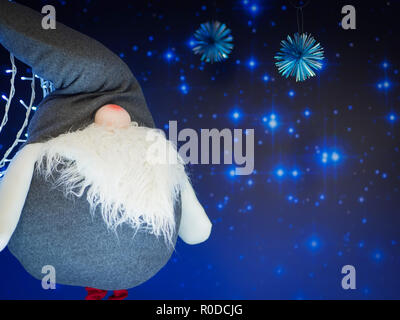 Un soft toy elf standing against starry fond bleu foncé. Noël et Nouvel An concept. Banque D'Images