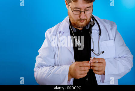 Medical doctor holding syring avec dans sa main et d'un costume Banque D'Images