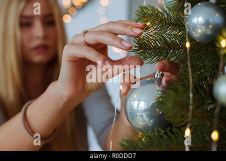 Young woman decorating Christmas Tree Banque D'Images