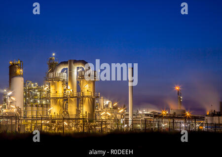 Paysage d'une installation industrielle chimique lourde avec mazework de tuyaux dans le crépuscule de scène de nuit Banque D'Images