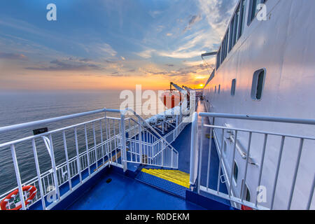 Escaliers et garde-corps sur le pont du paquebot de croisière à voile à travers le beau coucher du soleil sous la mer Banque D'Images