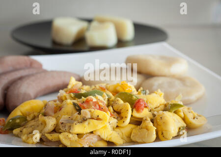 L'ackee et le poisson salé avec des bananes et de raviolis servi sur une plaque blanche Banque D'Images