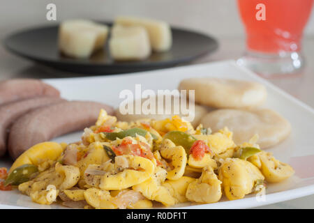 L'ackee et le poisson salé avec des bananes et de raviolis servi sur une plaque blanche Banque D'Images