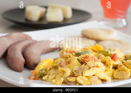 L'ackee et le poisson salé avec des bananes et de raviolis servi sur une plaque blanche Banque D'Images