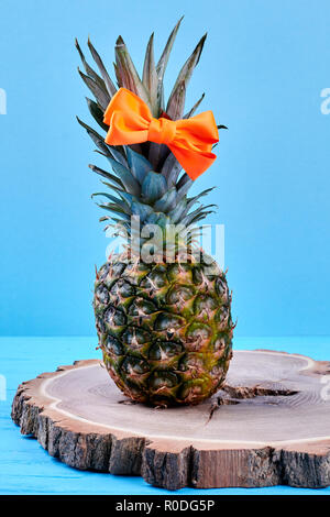 L'ananas avec cheveux bow on coupe en bois. Banque D'Images