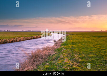 De soleil colorés sur un canal en campagne néerlandaise Banque D'Images