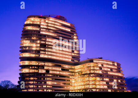 De longues heures de travail dans un grand immeuble de bureaux modernes avec des lumières au cours de l'Heure Bleue Banque D'Images