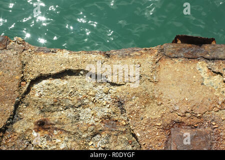 Détail de l'ancienne jetée en béton armé sur l'eau dans un soleil brillant Banque D'Images