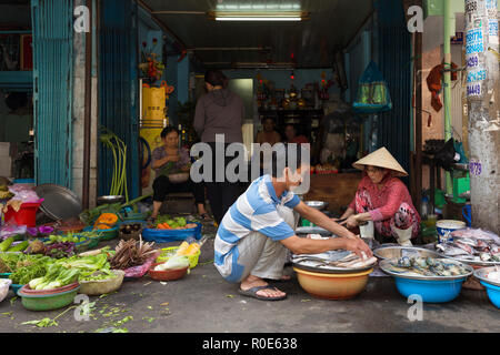 HO CHI MINH Ville, Vietnam, 26 février 2015 : une famille est la vente de légumes et poissons dans la rue au marché Binh Tay Cho dans le Chinatown d Banque D'Images