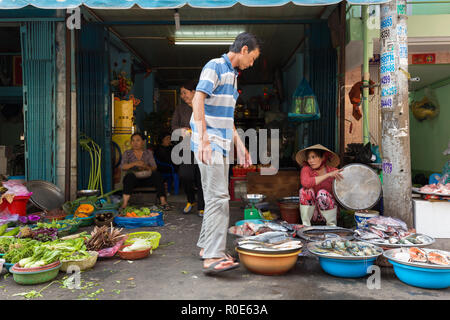 HO CHI MINH Ville, Vietnam, 26 février 2015 : une famille est la vente de légumes et poissons dans la rue au marché Binh Tay Cho dans le Chinatown d Banque D'Images