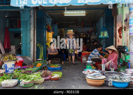 HO CHI MINH Ville, Vietnam, 26 février 2015 : une famille est la vente de légumes et poissons dans la rue au marché Binh Tay Cho dans le Chinatown d Banque D'Images