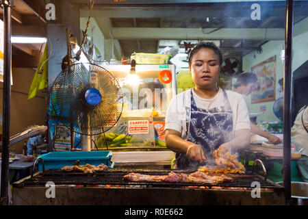 BANGKOK, THAÏLANDE,février 16,2015 : une femme est la cuisson sur barbecue Brochettes de poulet dans un petit restaurant de la Sukhumvit Soi 38 à Bangkok, Thaïlande Banque D'Images