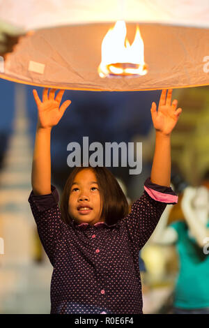 CHIANG MAI, Thaïlande, du 1 er janvier 2015 : Une petite fille est l'envoi d'un traditionnel feu de lanterne flottante le ciel et faire un souhait pour la nouvelle année en Banque D'Images