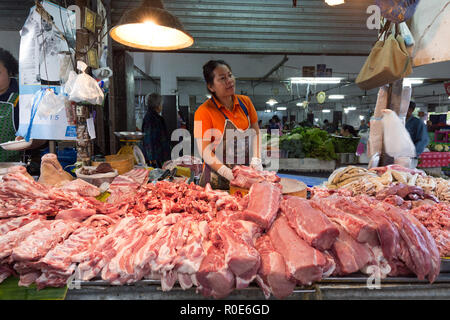 CHIANG MAI, Thaïlande, le 30 décembre 2014 : une femme butcher est la vente de la viande de porc dans le marché Pratu Talat dans Chiang Mai, Thaïlande Banque D'Images