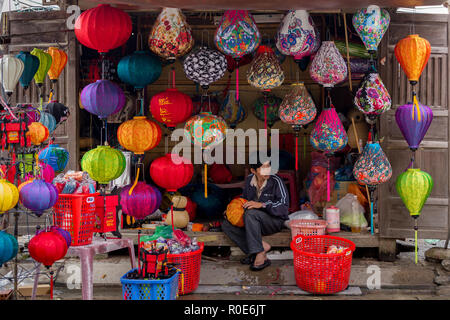 HOI AN VIETNAM, 14 décembre 2014 : Un homme est monté à la main en couleurs vente lanterne de papier dans les rues de Hoi An, Vietnam Banque D'Images