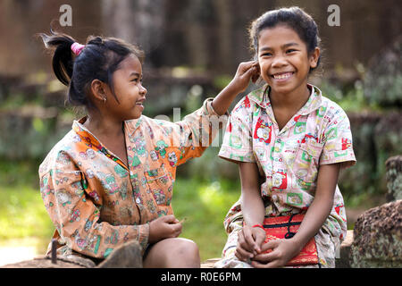 SIEM REAP, Cambodge, décembre 04, 2012 : Petite fille de pincer l'oreille de son ami, qu'ils utilisent pour se tenir là pour demander de l'argent au visiteurs près de th Banque D'Images