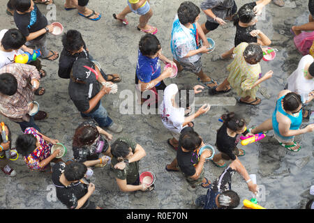 BANGKOK - 15 avril : foule de gens qui marchent dans la rue, jetant de l'eau et la poudre humide au cours de la nouvelle année Songkran Festival, 15 avril 2011, Silom roa Banque D'Images