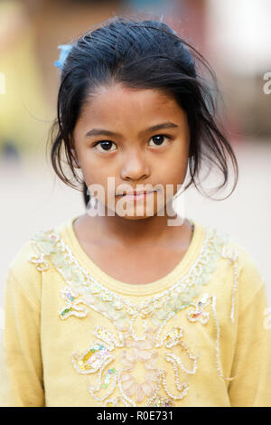 BHAKTAPUR, NÉPAL, 24 novembre 2010 : Portrait d'une petite fille népalaise posant dans le principal square Bhaktapur Banque D'Images