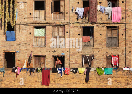 BHAKTAPUR, NÉPAL, 24 novembre 2010 : vue sur un ancien bâtiment traditionnel avec une façade à la pendaison de blanchisserie et windows sur un mur à Bhaktapur, Pen Banque D'Images