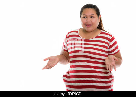 Studio shot of young Asian woman looking confus gras Banque D'Images