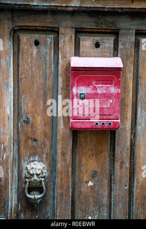 Rusty Red Letterbox sur la porte en bois, Italie Banque D'Images