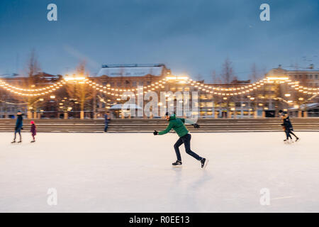 Portrait plein air de sportive active des hommes barbus qui participent à des activités de sports d'hiver, se prépare pour le concours de patinage sur l'anneau de glace de Noël décoré Banque D'Images