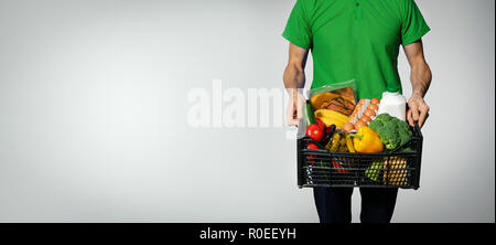 Service de livraison de nourriture - homme avec des provisions fort sur fond gris avec copie espace Banque D'Images